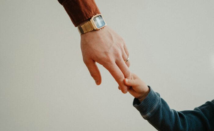 White Luing Law. Family Law and Divorce Lawyer. Blog Post. Minnesota Child Support Guide If I Make 1,000 A Week How Much Child Support Do I Pay. Image of a child holding his fathers hand.